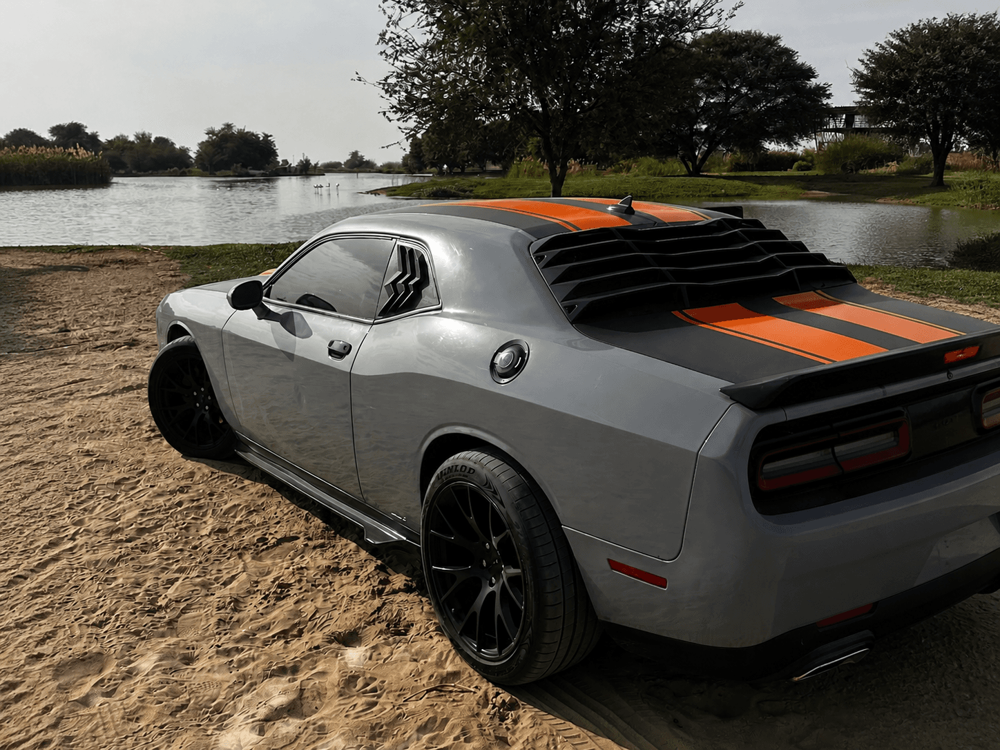 Grey Dodge Challenger parked beside a lake